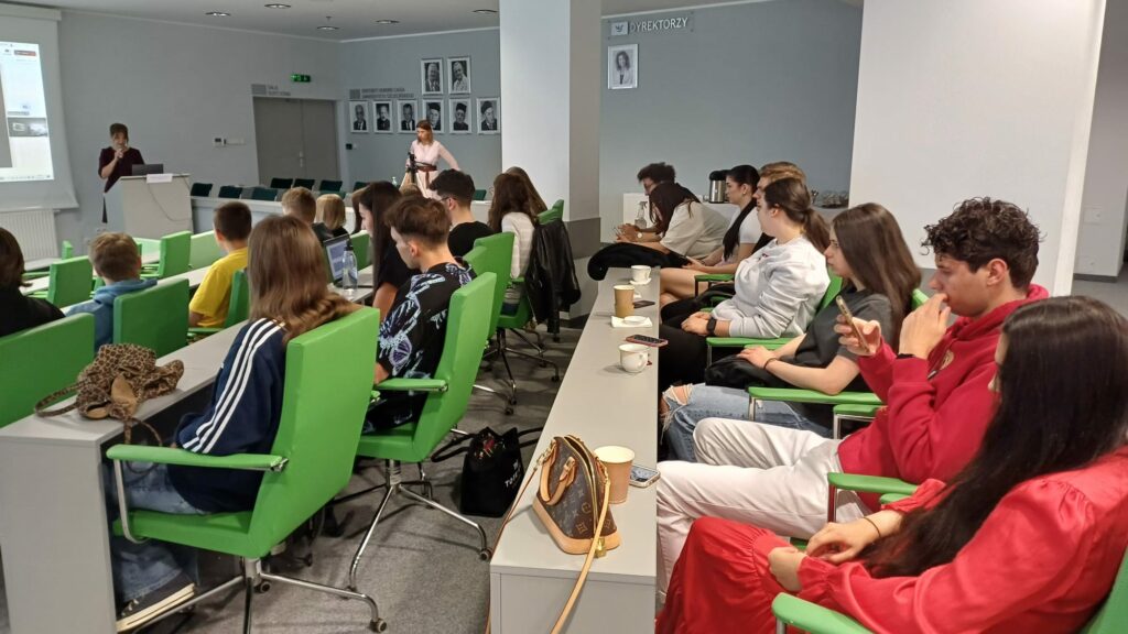 Spotkanie studentów i wykładowców w sali wykładowej.