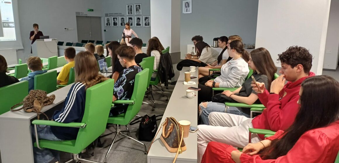 Grupa studentów siedzi w sali wykładowej.