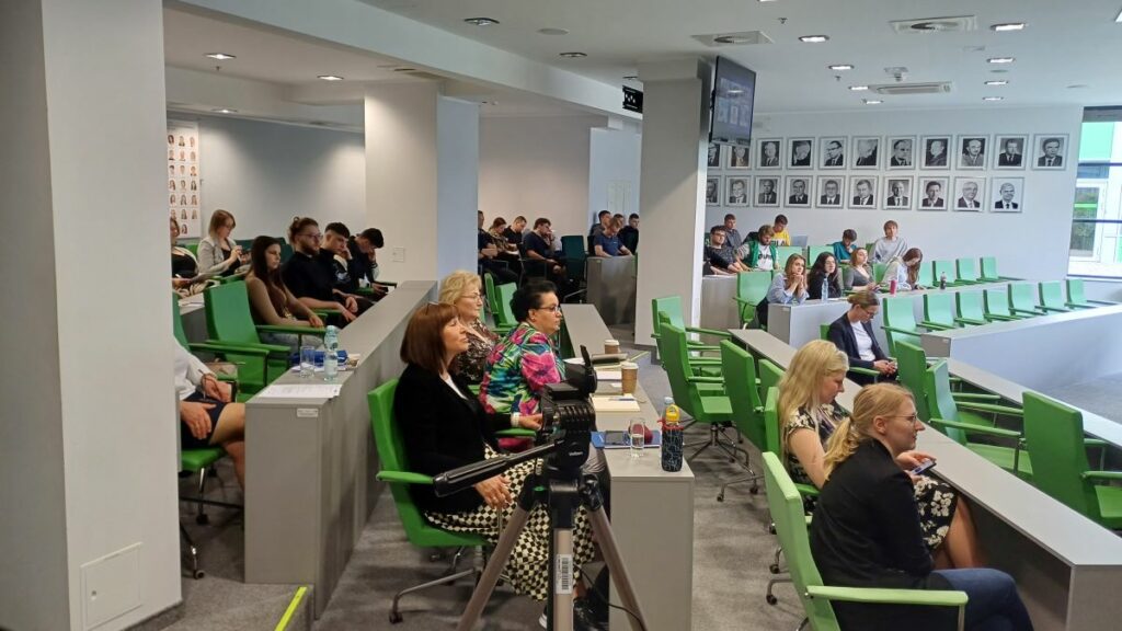 Spotkanie studentów i wykładowców w sali wykładowej.