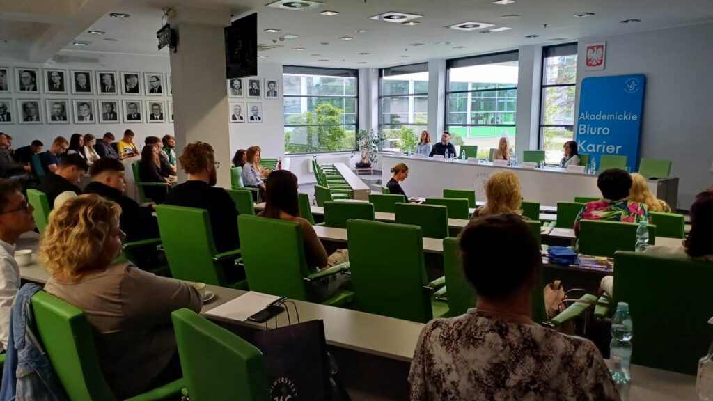 Spotkanie studentów i wykładowców w sali wykładowej.