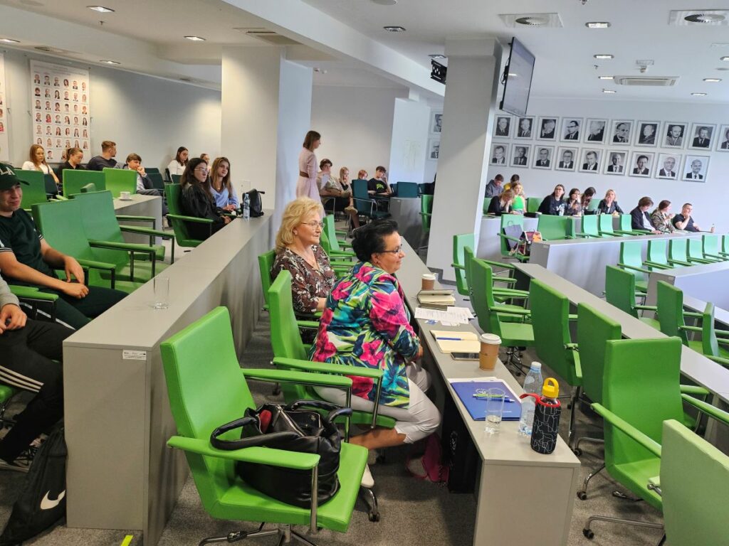 Spotkanie studentów i wykładowców w sali wykładowej.